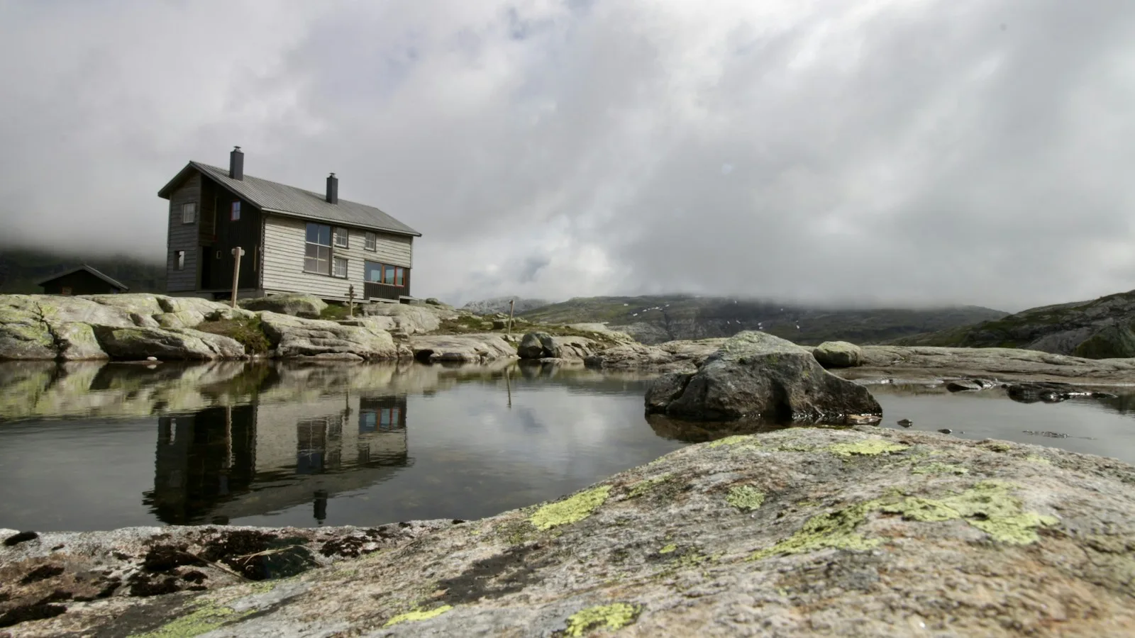 Cabane en bois rouge du réseau DNT isolée au milieu des montagnes norvégiennes